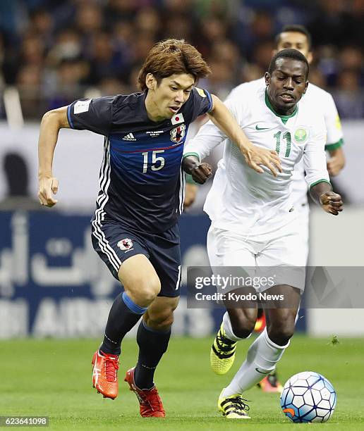 Yuya Osako of Japan and Abdulmalek Al Khaibri of Saudi Arabia battle for the ball during the first half of a Group B match of an Asian World Cup...