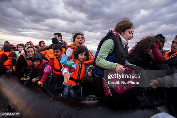Syrian and many Afghan migrants / refugees arrive from Turkey on boat through sea with cold water near Molyvos, Lesbos on overloaded dinghies....