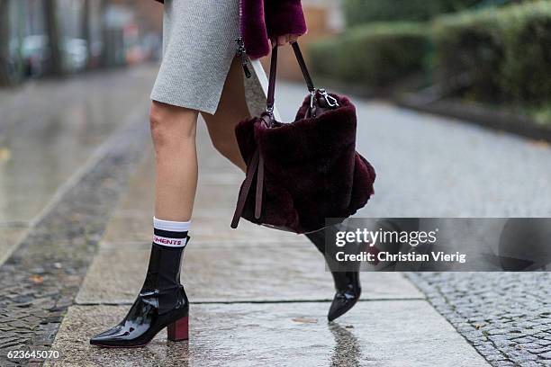 Lisa Hahnbueck wearing a bordeaux Aigner Faux Fur Bomber Jacket, a grey Duffy Cashmere Knit, Aeyde Patent Leather Naplak Ankle Boots, Aigner Carla...