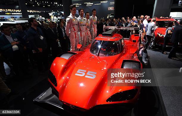 Racing team members unveils the Mazda RT24-P DPi challenger racing car at the Mazda press conference during media preview days ahead of the public...