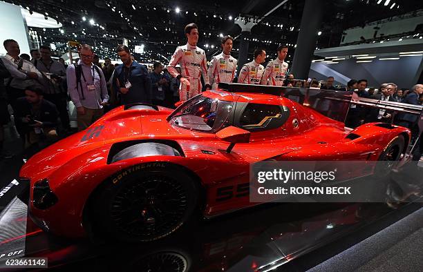 Racing team members unveils the Mazda RT24-P DPi challenger racing car at the Mazda press conference during media preview days ahead of the public...