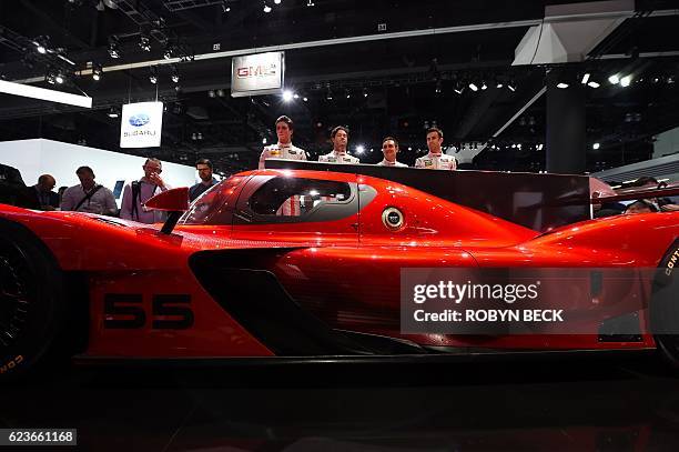 Racing team members unveils the Mazda RT24-P DPi challenger racing car at the Mazda press conference during media preview days ahead of the public...
