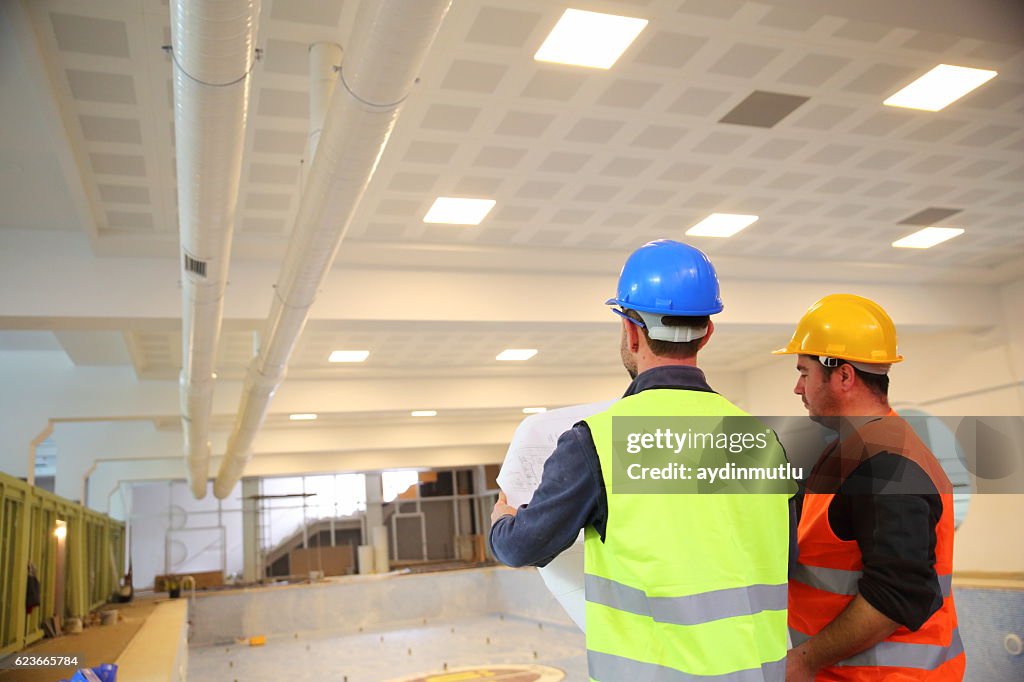 Construction workers reading blueprints