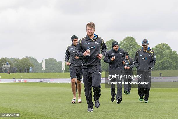 Tim Southee, James Neesham, Head Coach Mike Hesson and Kane Williamson of New Zealand run from the ground as rain delays play during day one of the...