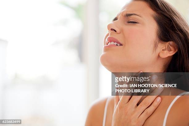 woman with hand on throat in pain - throat photos fotografías e imágenes de stock