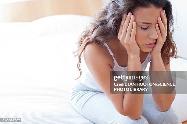 woman on bed in pain - hoofdpijn vrouw stockfoto's en -beelden