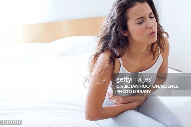 woman on bed with cramps - dor de barriga imagens e fotografias de stock