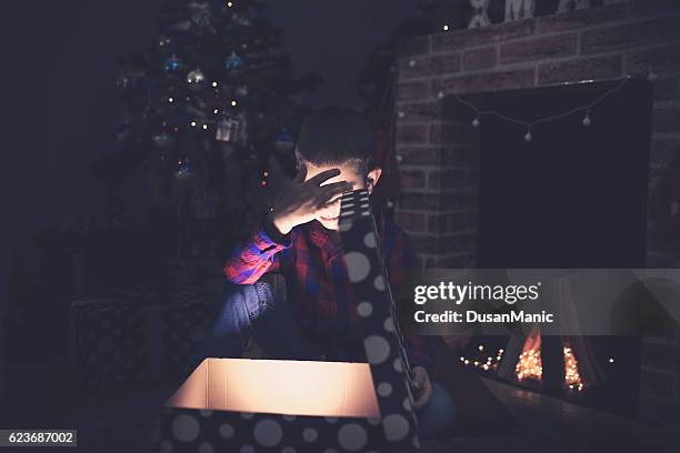 surprised child opening and looking inside a magic gift - face surprise heat stock pictures, royalty-free photos & images