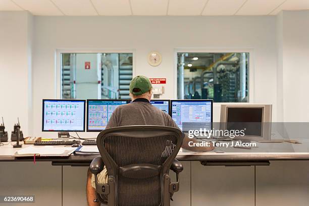 technician at the computers in a control room - kontrollrum bildbanksfoton och bilder