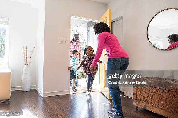 mother answering the door to her family - open day 5 stockfoto's en -beelden