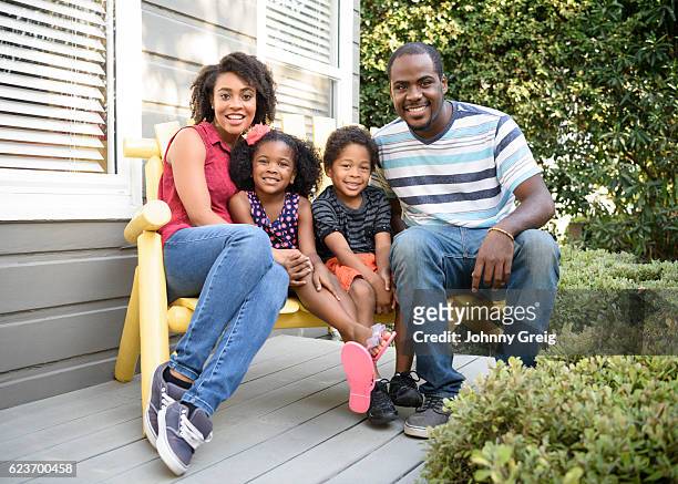 young african american family sitting on bench outside house - family porch stock pictures, royalty-free photos & images