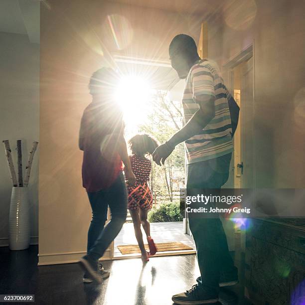 parents with daughter leaving  the house in bright sunlight - 離去 個照片及圖片檔