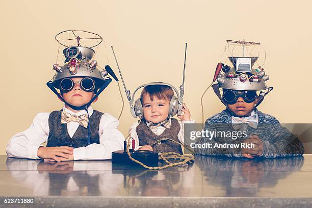 tres niños vestidos como nerds con cascos de lectura mental - genius fotografías e imágenes de stock