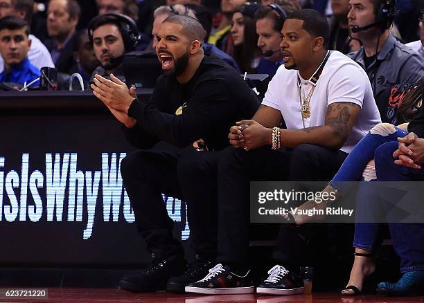 Drake cheers from his courtside seat during the first half of an NBA game between the Golden State Warriors and the Toronto Raptors at Air Canada...