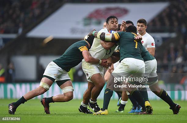 Billy Vunipola of England is tackled by Warren Whiteley and Tendai Mtawarira of South Africa during the Old Mutual Wealth Series match between...