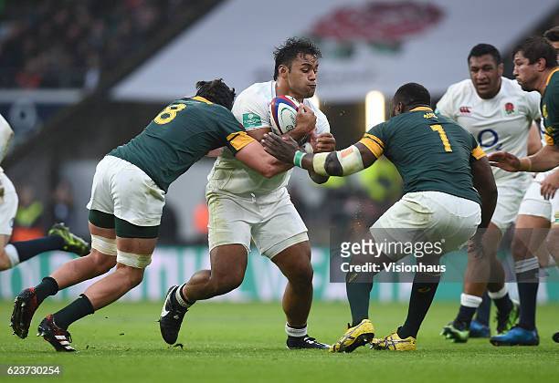 Billy Vunipola of England is tackled by Warren Whiteley and Tendai Mtawarira of South Africa during the Old Mutual Wealth Series match between...