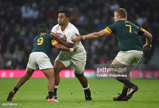 Billy Vunipola of England is tackled by Rudy Paige and Pieter-Steph du Toit of South Africa during the Old Mutual Wealth Series match between England...