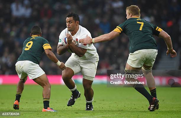 Billy Vunipola of England is tackled by Rudy Paige and Pieter-Steph du Toit of South Africa during the Old Mutual Wealth Series match between England...