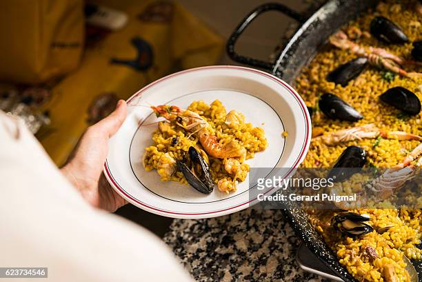serving paella - paella photos et images de collection