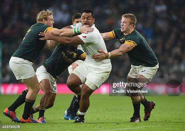 Billy Vunipola of England is tackled by Adriaan Strauss, Rudy Paige and Pieter-Steph du Toit of South Africa during the Old Mutual Wealth Series...