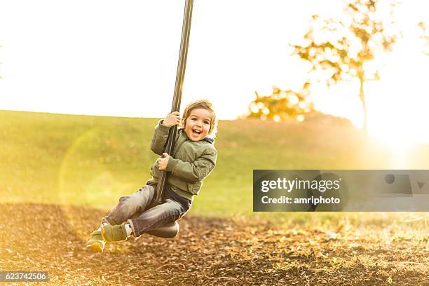 cute three year old boy on a zipline in backlight - zipline stock pictures, royalty-free photos & images