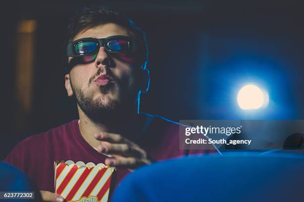 guy enjoying popcorn at the cinema - cinema projector stock pictures, royalty-free photos & images
