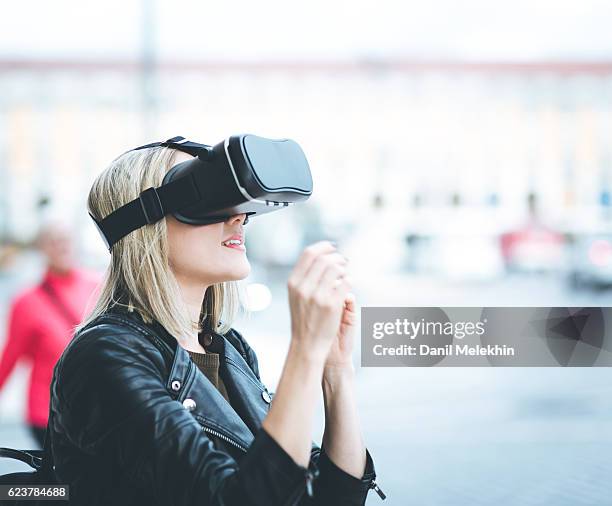 women testing virtual reality simulator on the street - virtual reality headset stockfoto's en -beelden