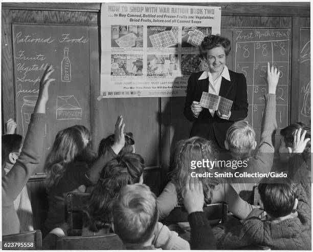 Sixth grade teacher shows her pupils on how to use War Ration Book Two, February, 1943. .