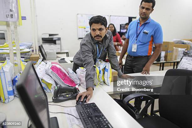 Abdul Saleem, a deliveryman known as a Wishmaster for Flipkart Online Services Pvt's Ekart Logistics service, right, watches a colleague use a...