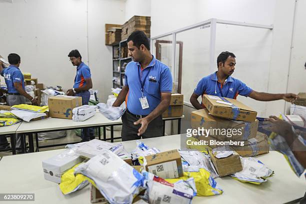 Abdul Saleem, a deliveryman known as a Wishmaster for Flipkart Online Services Pvt's Ekart Logistics service, center, sorts packages at the company's...