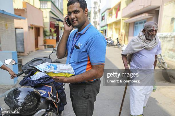 Abdul Saleem, a deliveryman known as a Wishmaster for Flipkart Online Services Pvt's Ekart Logistics service, uses a smartphone in Bengaluru, India,...