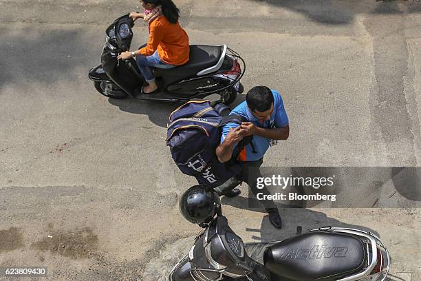 Abdul Saleem, a deliveryman known as a Wishmaster for Flipkart Online Services Pvt's Ekart Logistics service, carries a bag towards his motorcycle in...