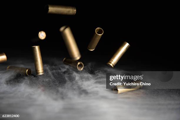 smoking bullets falling on ground - ammunition fotografías e imágenes de stock