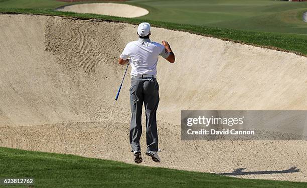 Sergio Garcia of Spian leaps to see the line before he plays his second shot from a deep fairway bunker on the first hole during the first round of...