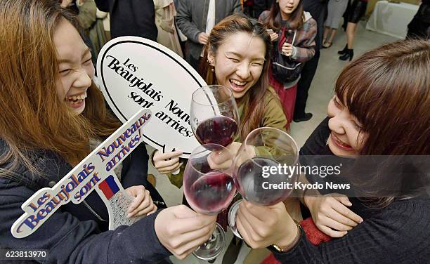 Drinkers raise glasses of Beaujolais Nouveau on Nov 2016, immediately after the French wine was released at an event in Tokyo.