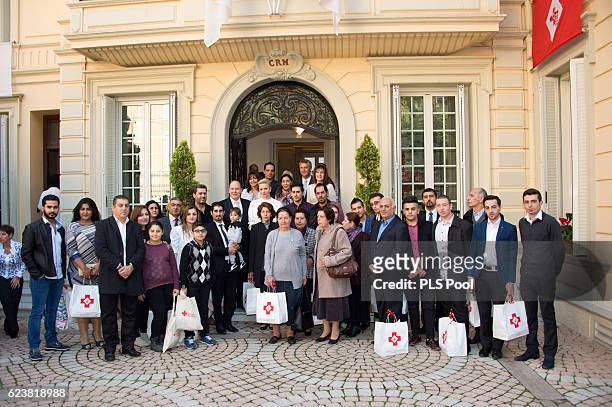 Prince Albert II of Monaco and Princess Charlene of Monaco pose with refugees during the Parcels Distribution At Monaco Red Cross Headquarters on...