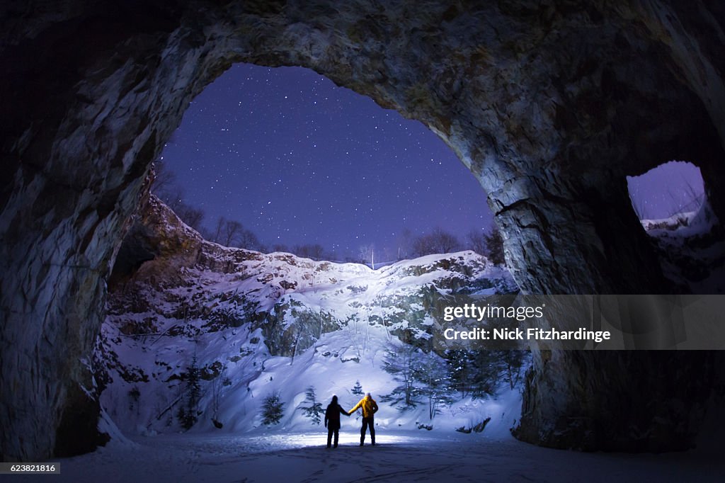 Two people holding hands in an an underground cavern, Wallingford Back Mine, Quebec, Canada