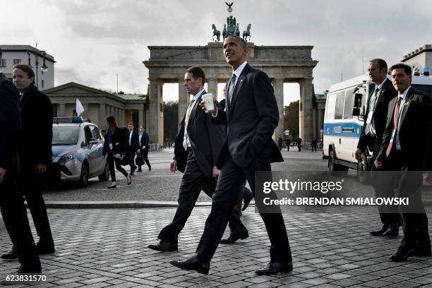President Barack Obama passes the Brandenburg Gate while walking from the US Embassy to the Adlon Hotel November 17, 2016 in Berlin, Germany. US...