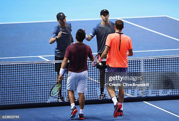 Bob Bryan and Mike Bryan of the United States are congratulated by Max Mirnyi of Belarus and Treat Huey of Philippines after their men's doubles...