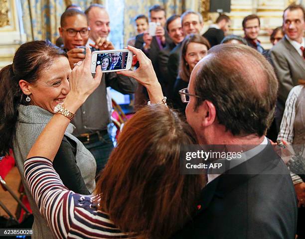 French President Francois Hollande poses for a selfie with a member of the public after delivering a speech about the future of the civil service...