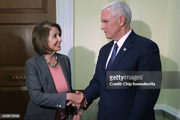 Vice President-elect Mike Pence and House Minority Leader Nancy Pelosi pose for photographs following a meeting in her offices at the U.S. Captiol...