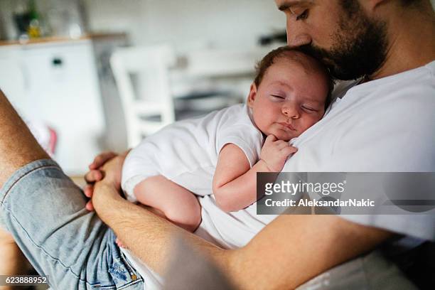 napping time - father holding sleeping baby stockfoto's en -beelden