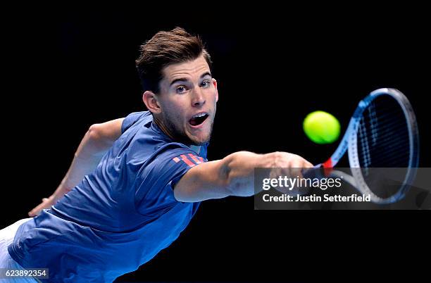 Dominic Thiem of Austria plays a backhand in his men's singles match against Milos Raonic of Canada on day five of the ATP World Tour Finals at O2...