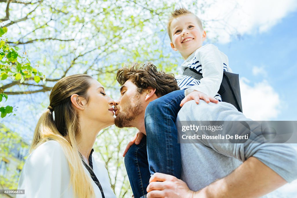 Mother Kissing Goodbye Husband And Son Before Going To Work