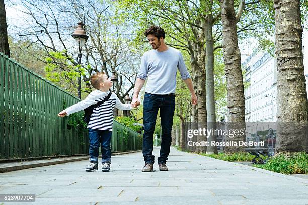 père et fils marchant dans le parc, allant à l’école - ballade famille photos et images de collection