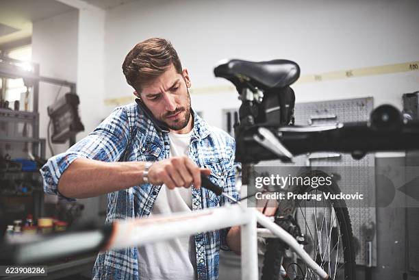 mechanic repairing bicycle wheel - repair shop stock pictures, royalty-free photos & images