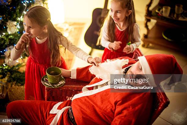 little girls and a family member dressed as santa - naughty santa stock pictures, royalty-free photos & images