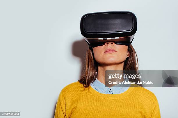 junge frau benutzt virtuelle realität gläser - virtual reality glasses stock-fotos und bilder