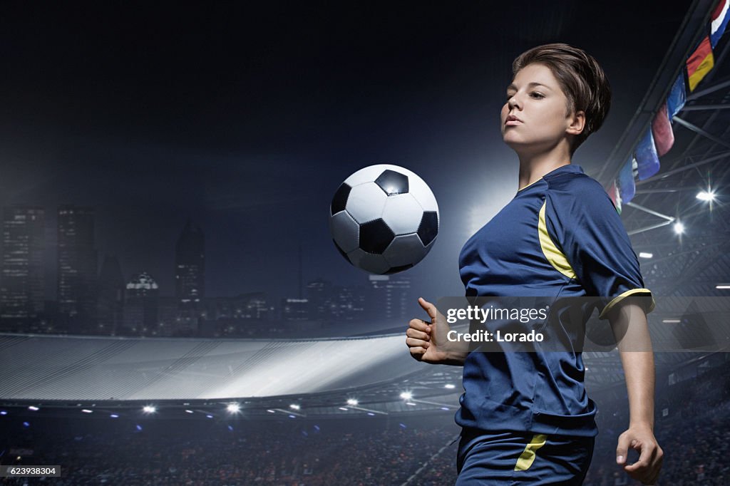 Kaukasische junge erwachsene Fußballspielerin spielt Fußball im Stadion
