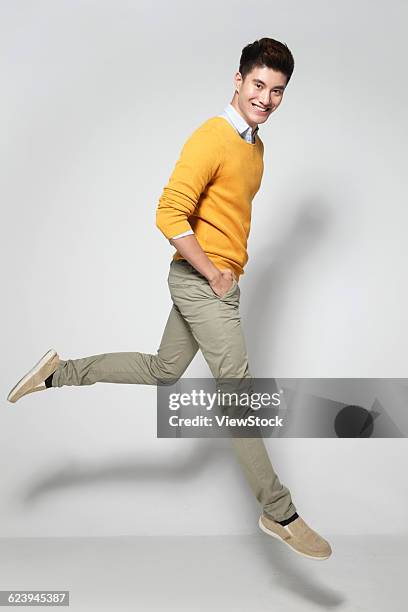 young man leaping - jumping casual clothing studio shot stock pictures, royalty-free photos & images